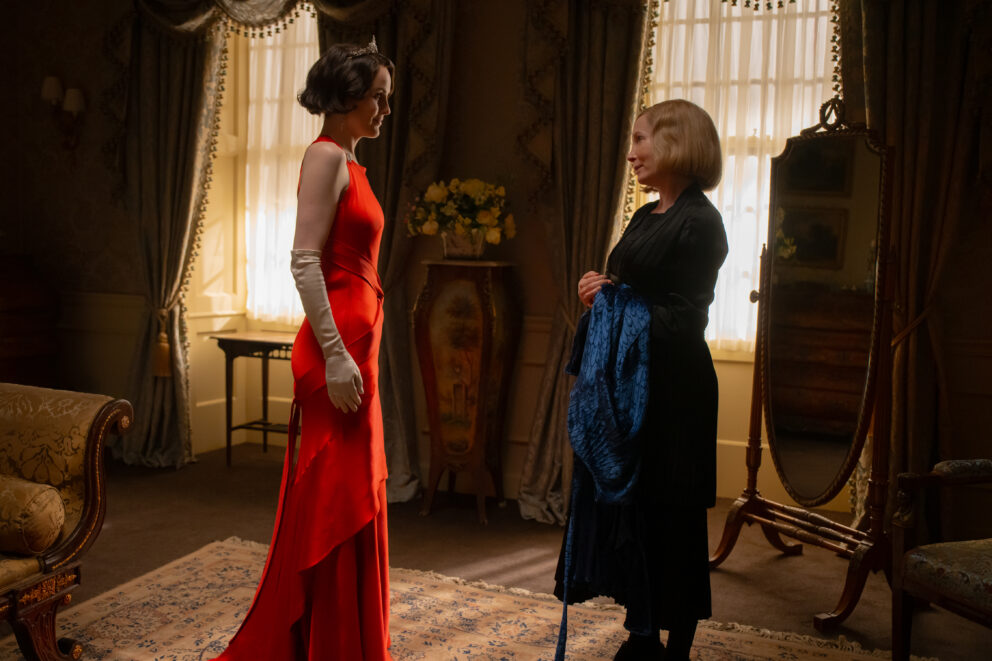 Two characters from Downton Abbey, facing each other in a grand room.