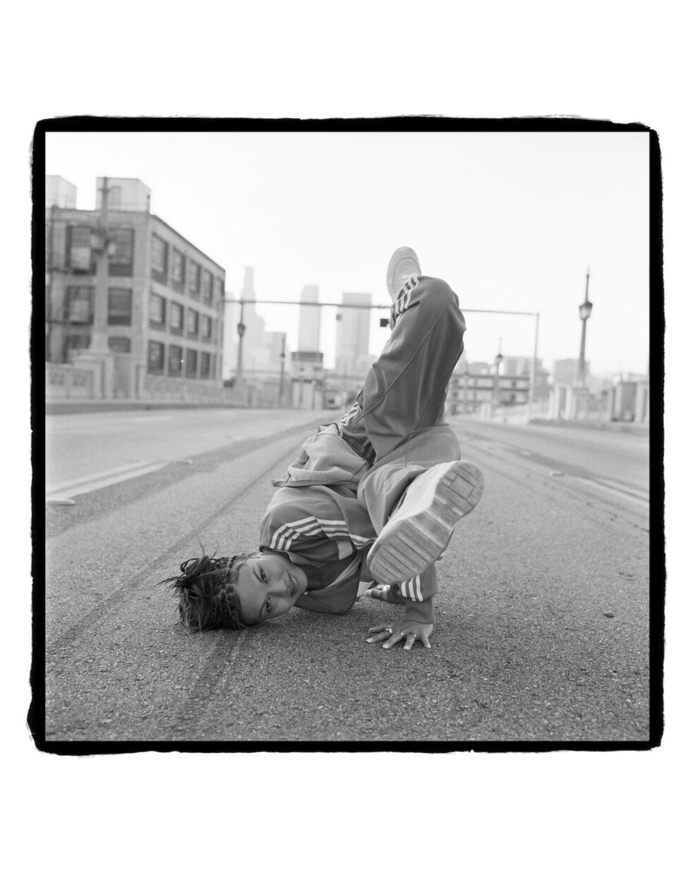 A black and white image of a break dancer on the street.