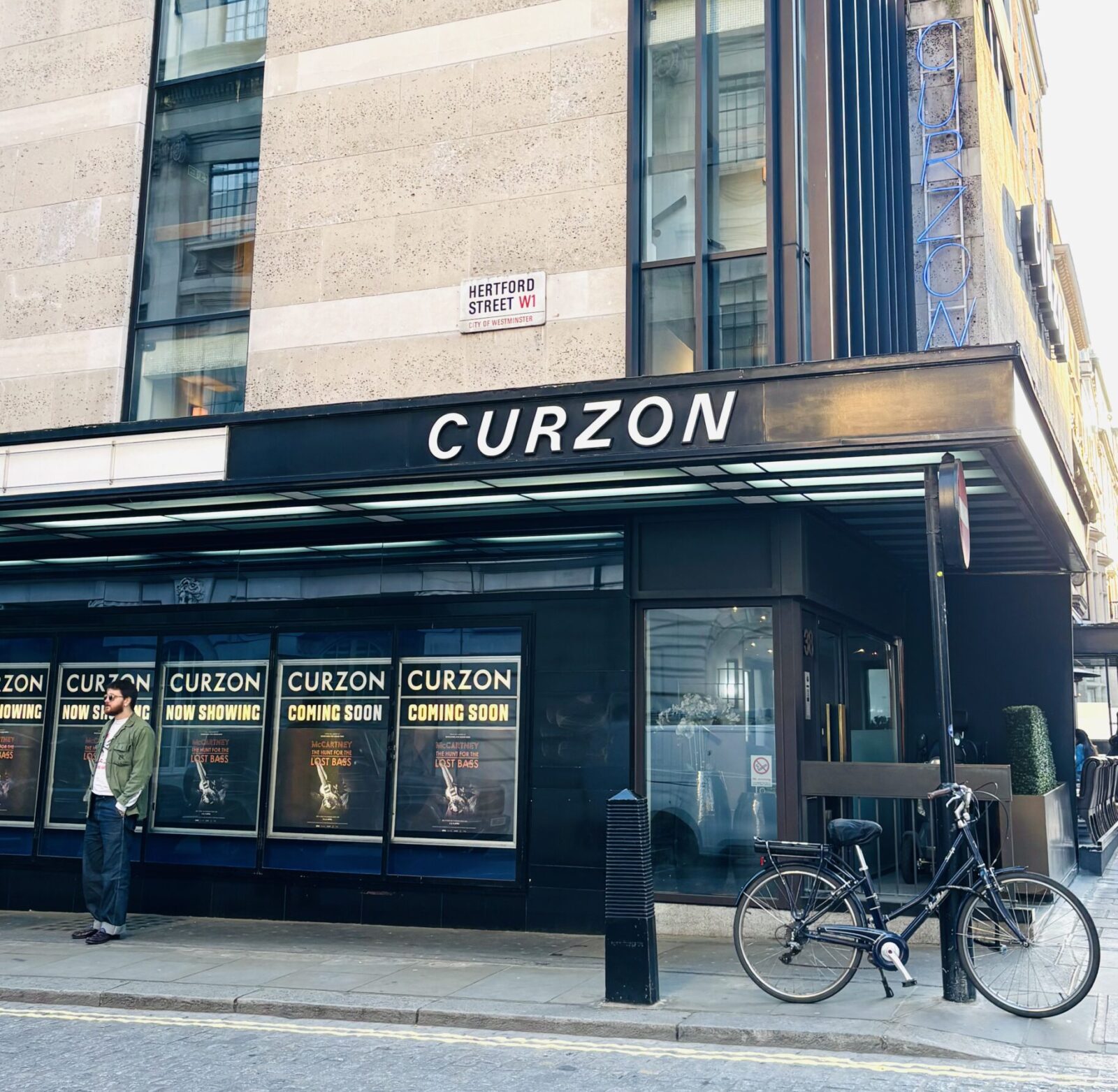 The concrete and black exterior of the Curzon Mayfair cinema with a visitor standing outside.
