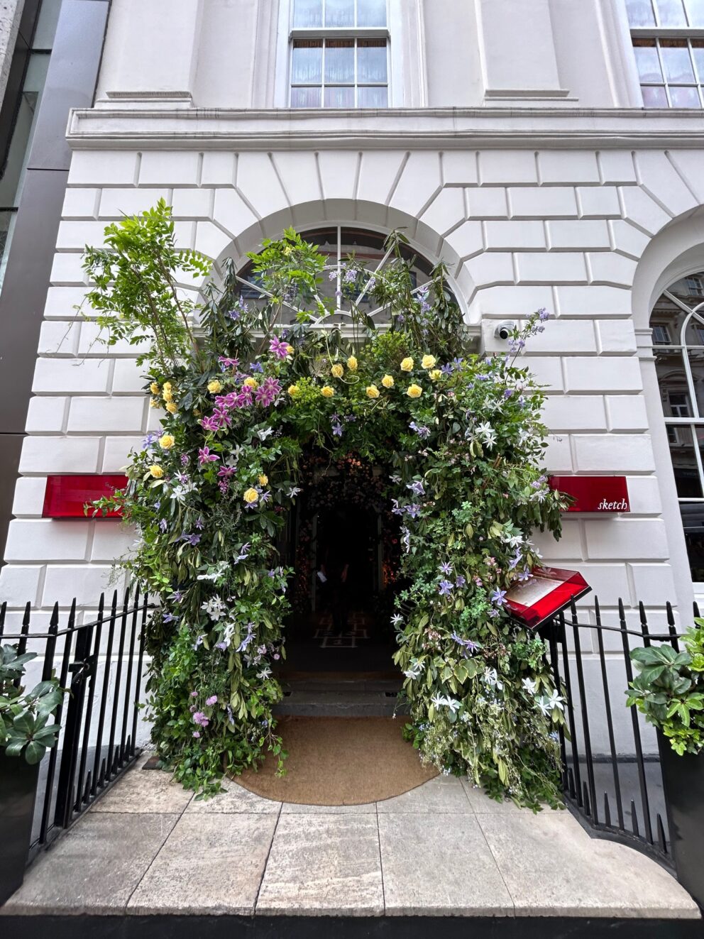 The entrance to Sketch on Conduit Street with the doorway adorned with flowers.