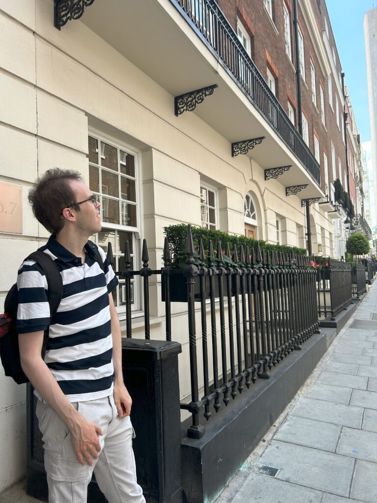 A male guest standing outside the front door of 9 Hertford Street.