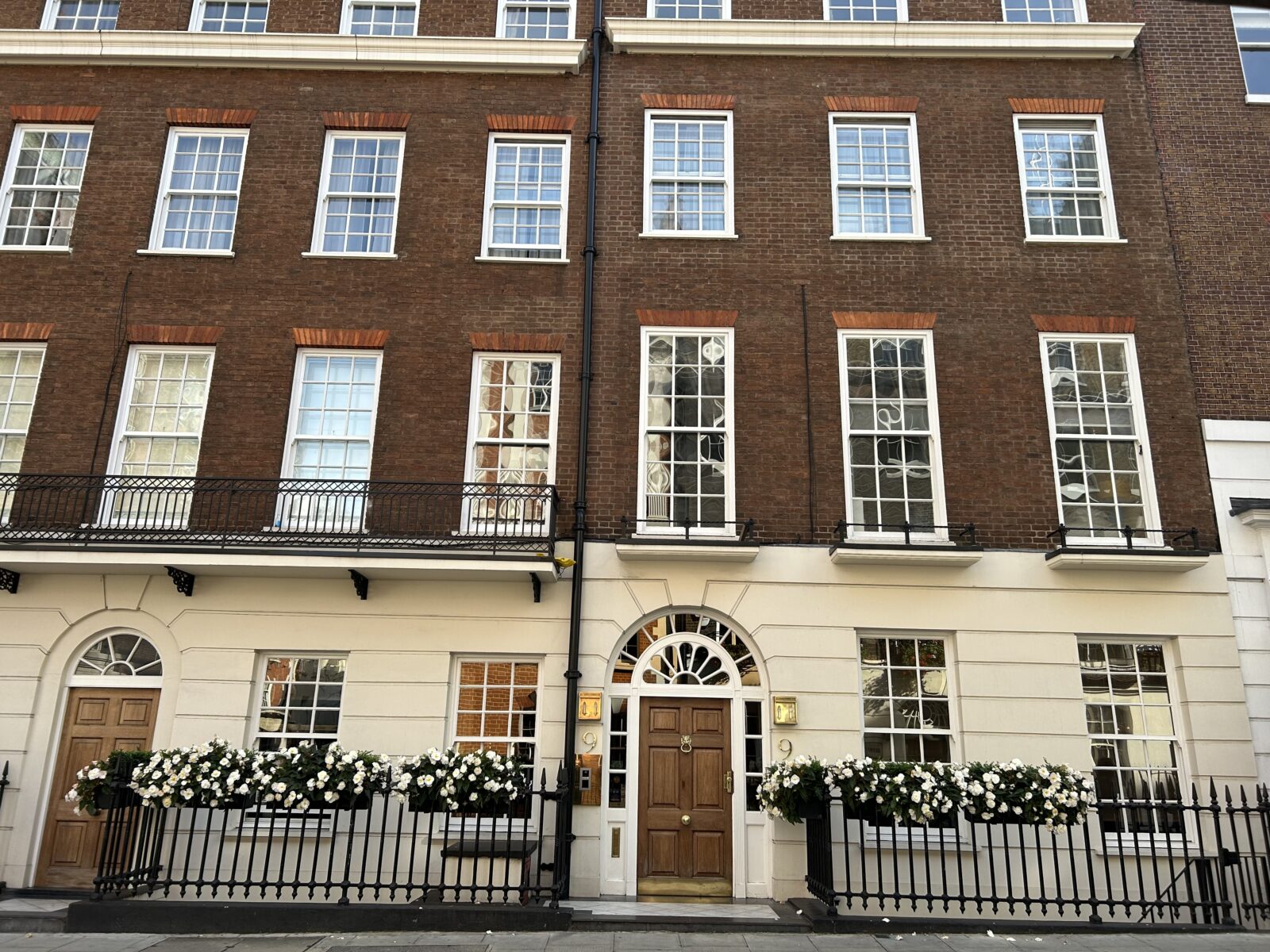 The Georgian facade of 8 & 9 Hertford Street with sash windows and fanlights over doors.