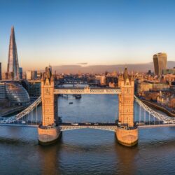 The London skyline, taken from above the Thames near Tower Bridge with iconic structures like the Shard in the distance.