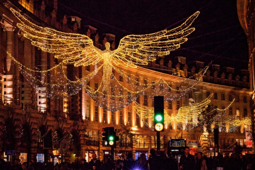A London street in the dark, with festive angel lights illuminated over the street.